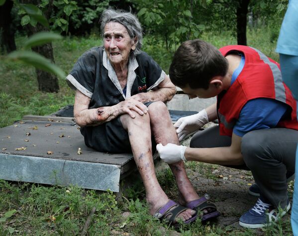 Санитар обрабатывает раны пожилой женщине