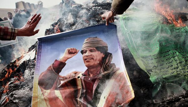 Житель Бенгази сжигает портрет Муамара Каддафи. Архивное фото.