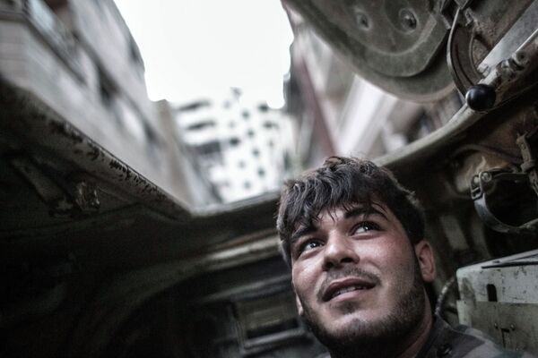 Военнослужащий правительственных войск внутри бронетранспортера во время столкновений с боевиками в центре Хомса