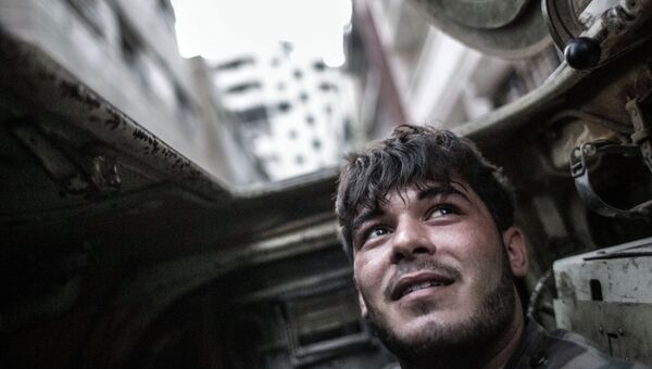 Военнослужащий правительственных войск внутри бронетранспортера во время столкновений с боевиками в центре Хомса