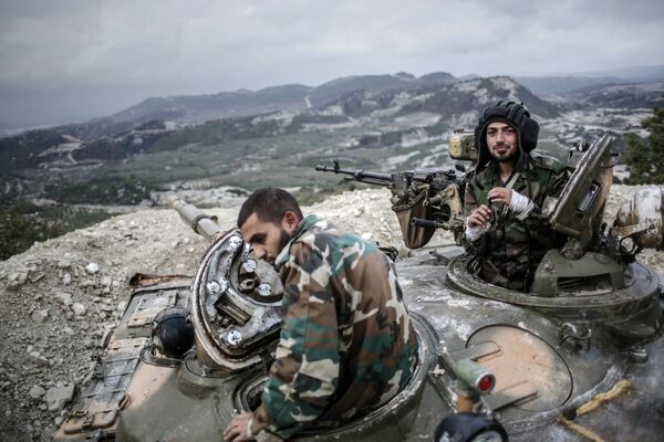 Танкисты правительственных войск сирийской армии на вершине холма в провинции Латакия рядом с турецкой границей