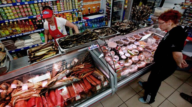 Женщина рассматривает рыбную продукцию в магазине. Архивное фото