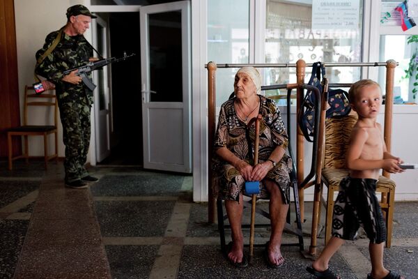 Ополченец и беженцы в здании Национального университета в Донецке