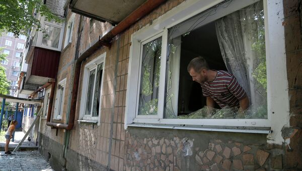 Местный житель осматривают повреждения после обстрела жилого дома в Донецке. Архивное фото