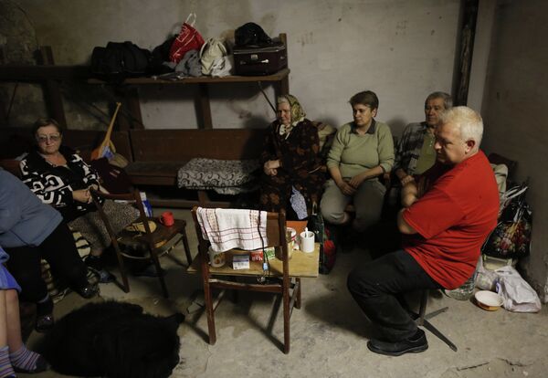 Жители города Ясиноватая прячутся в подвале своего дома от артобстрела
