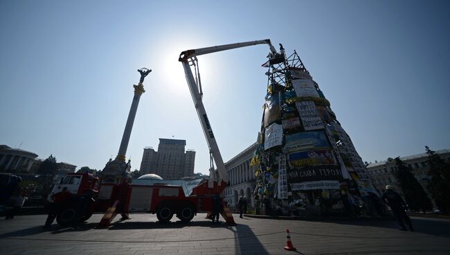 Рабочие снимают плакаты с новогодней елки на площади Независимости в Киеве. Архивное фото