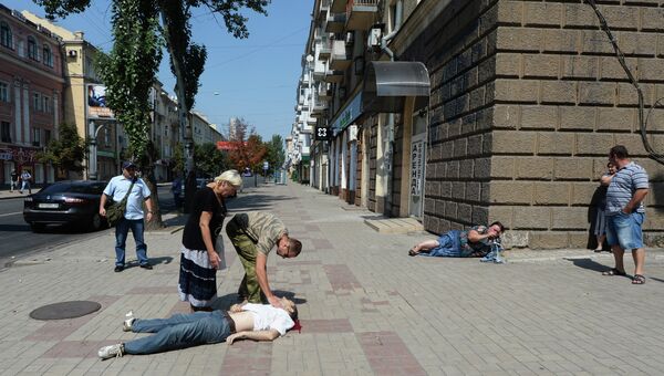 Жители Донецка на одной из улиц города, где произошел обстрел мирных жителей. Архивное фото