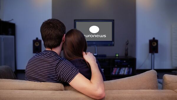 Девушка и молодой человек смотрят телевизор. Архивное фото