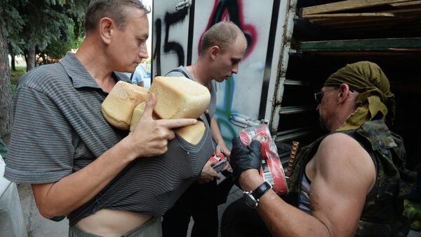 Жители Иловайска разбирают хлеб, привезенный им ополченцами