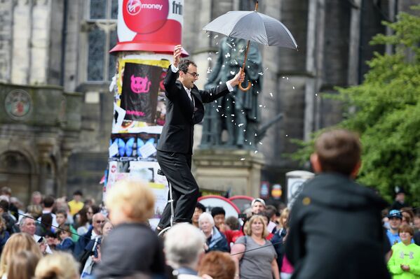 Акробат среди зрителей на Королевской Миле во время Эдинбургского фестиваля