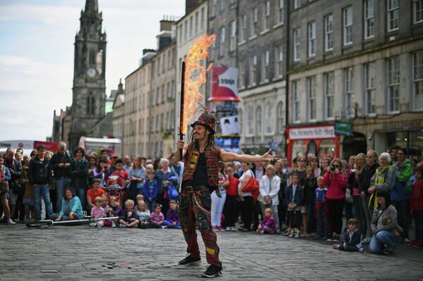 Огнеглотатель на Королевской Миле показывает трюки с огнем во время Эдинбургского фестиваля