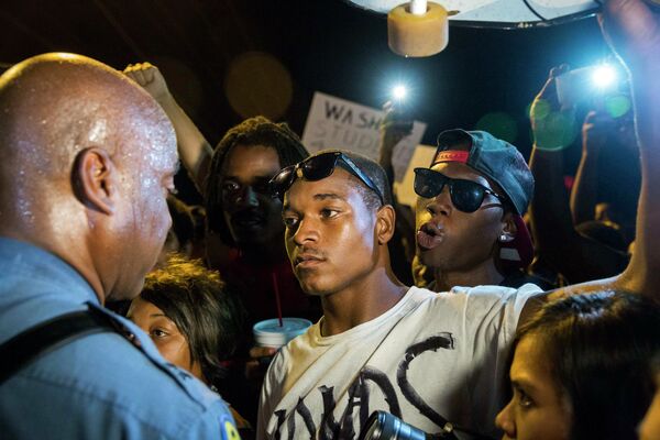 Полицейский Рон Джонсон общается с протестующими в пригороде Сент-Луиса, США