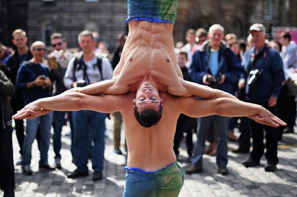 Акробаты показывают трюки на Королевской Миле во время Эдинбургского фестиваля