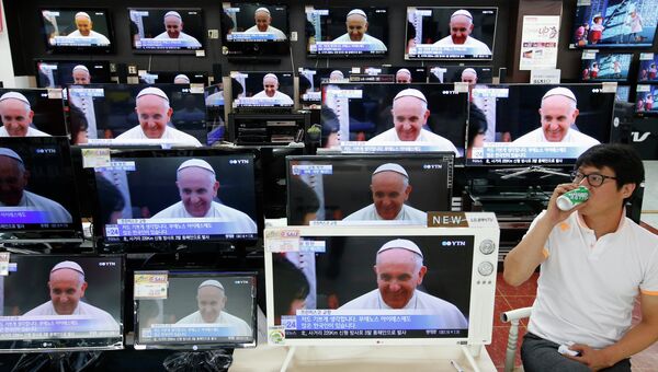 Трансляция визита Папы Римского Франциска на экранах магазина бытовой техники в Сеуле