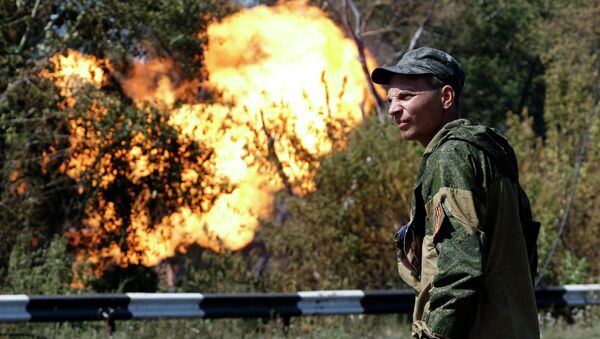 Боец народного ополчения возле газопровода, который загорелся в результате обстрела Донецка 15 августа 2014. Архивное фото
