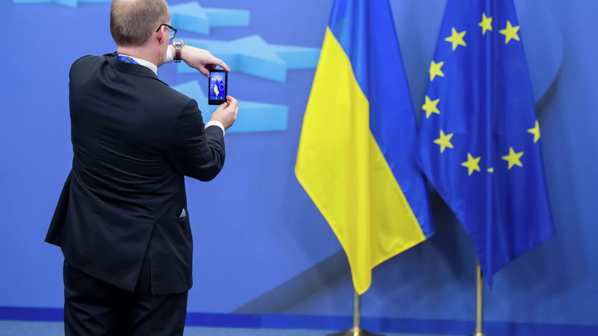 Человек фотографирует флаги Украины и Евросоюза - РИА Новости, 1920, 10.11.2022