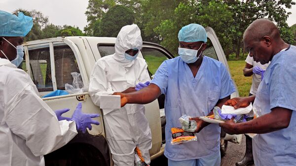 Медицинские работники передают средства индивидуальной защиты от лихорадки Эбола в Либерии