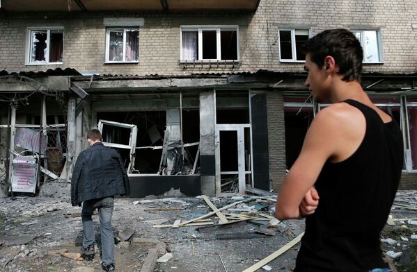 Местные жители у разрушенных в результате обстрела силовиками домов в Макеевке, Украина
