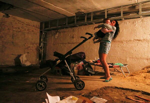 Местная жительница с ребенком в Макеевке, Донецкая область, Украина
