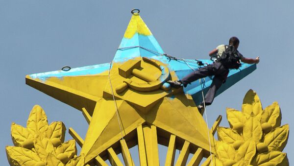 Рабочий закрашивает звезду на шпиле высотного здания на Котельнической набережной в Москве. Архивное фото