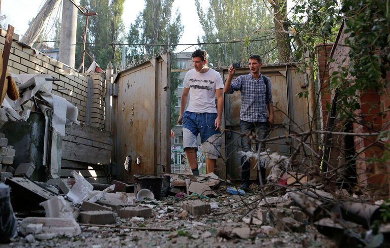 Жители Донецка во дворе жилого дома после обстрела