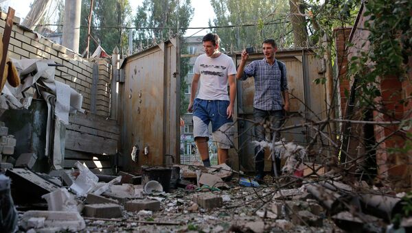 Жители Донецка во дворе жилого дома после обстрела