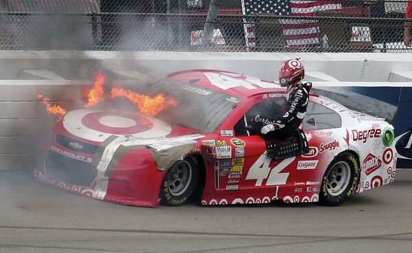 Горящий автомобиль гонщика Кайла Ларсона во время гонки серии NASCAR в Мичигане