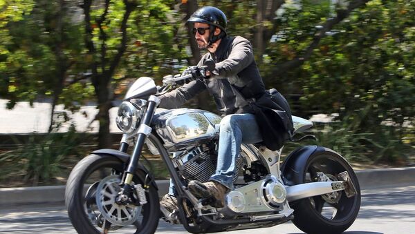 Каину Ривз едет на своем мотоцикле по Беверли Хиллс