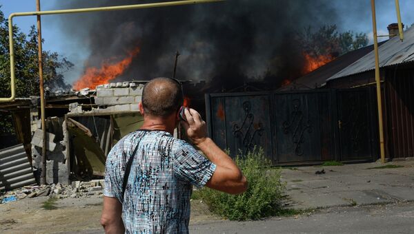 Мужчина у горящего дома в Петровском районе Донецка. Архивное фото