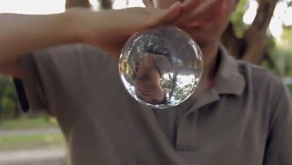 Мальчик жонглирует стеклянным шаром