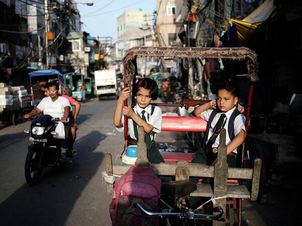 Школьники в одной из рикш в старых кварталах Дели