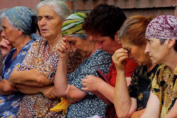 Женщины ждут новостей недалеко от захваченной школы в Беслане 1 сентября 2004