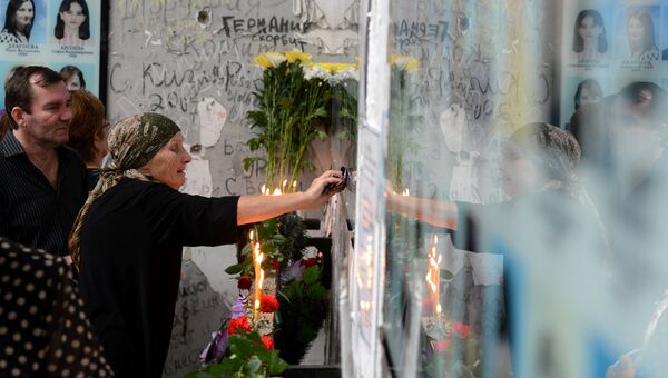 Женщина плачет на траурном мероприятии в годовщину трагедии в Беслане. Архив