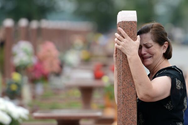 Женщина плачет на мемориальном кладбище Город ангелов в Беслане