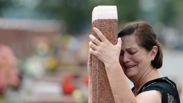 Женщина плачет на мемориальном кладбище Город ангелов в Беслане. Архивное фото