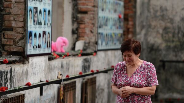 Женщина плачет на траурном мероприятии в годовщину трагедии в Беслане