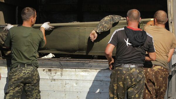 Украинские военные грузят в грузовик тела погибших товарищей