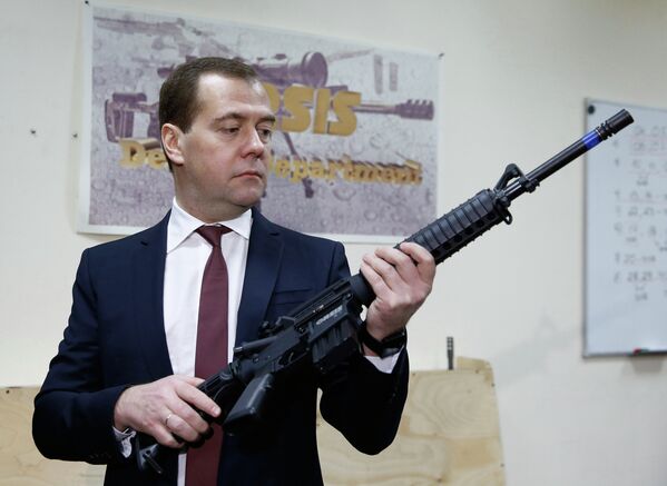 Дмитрий Медведев осматривает образцы стрелкового оружия российского производства во время посещения ООО Промтехнология
