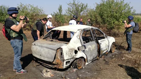 Сгоревший автомобиль на месте гибели фотокорреспондента МИА Россия сегодня Андрея Стенина