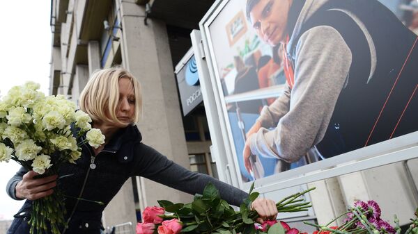 Коллега возлагает цветы в память о погибшем на Украине фотокорреспонденте Андрее Стенине у здания МИА Россия сегодня