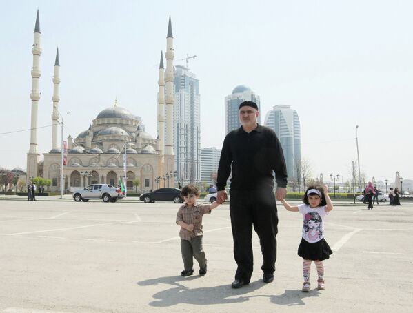 Мужчина с детьми на площади у мечети Сердце Чечни имени Ахмата Кадырова