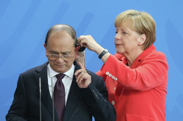 Германский канцлер Ангела Меркель поправляет наушник президенту Мьянмы Тейн Сейну