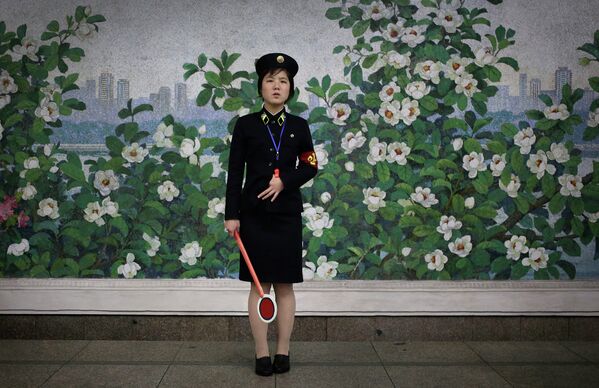 Сотрудница северокорейского метро ждет прибытия поезда