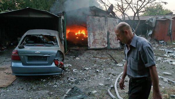 Житель у горящего в результате обстрела Украинскими военными строения в Донецке