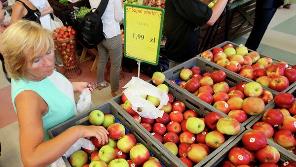 Женщина покупает яблоки в магазине в Варшаве. 6 августа 2014