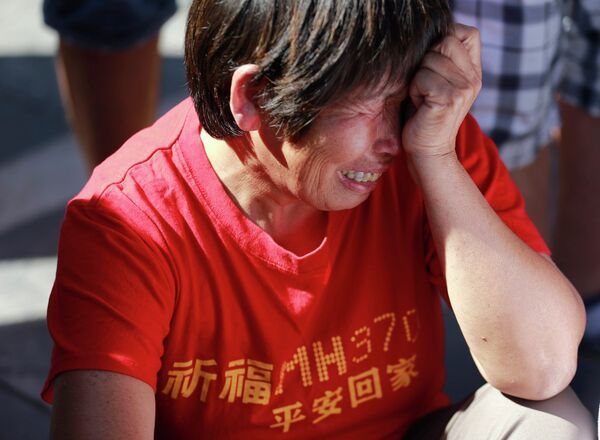 Родственники и друзья пассажиров пропавшего рейса MH370 Malaysia Airlines собираются на молитву в Пекине