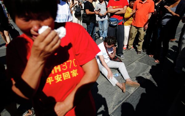 Родственники и друзья пассажиров пропавшего рейса MH370 Malaysia Airlines собираются на молитву в Пекине