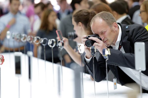 Мужчина фотографирует часы Apple Whatches во время презентации Apple в Купертино, США
