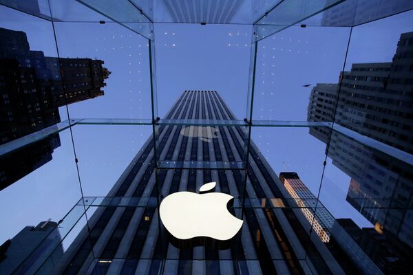 Логотип компании Apple над входом в здание в Нью-Йорке, США