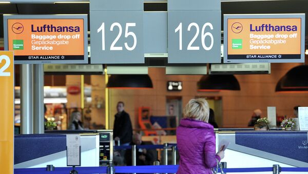 Пассажирка стоит у стойки регистрации авиакомпании Lufthansa
